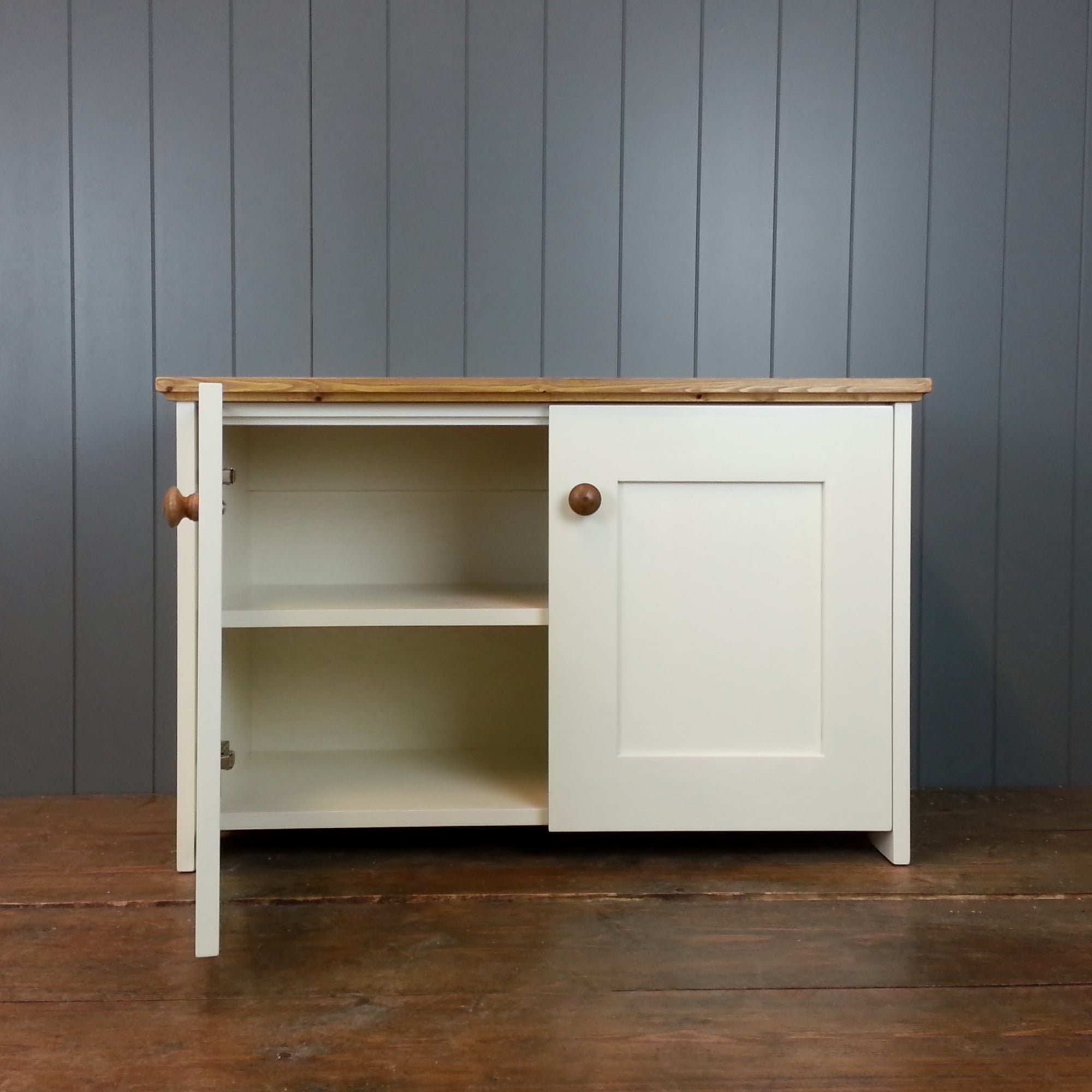A painted cupboard with two deep storage shelves. Antique white with antique pine knobs and top.