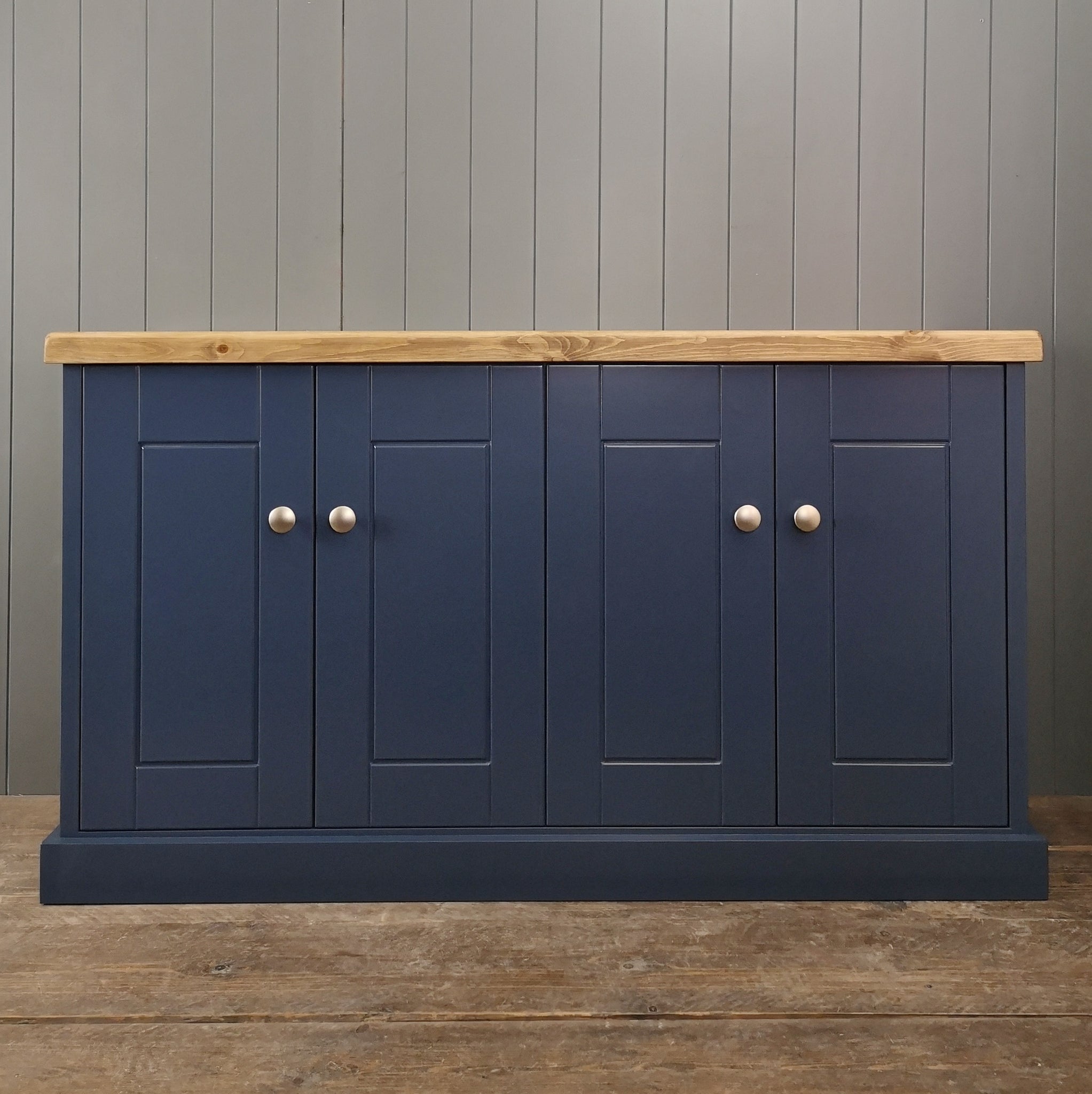 Large painted cupboard with brushed satin knobs and a rustic antique pine top.