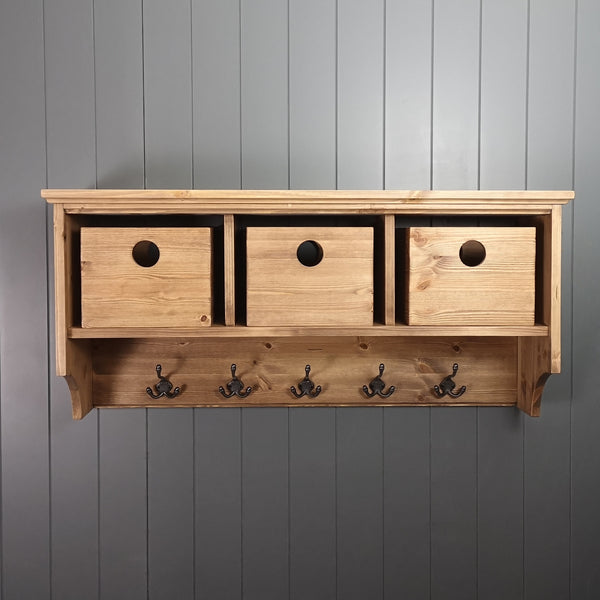 An antique pine stained coat rack with antique pine storage boxes