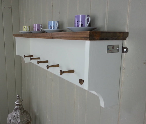Kitchen rack or hallway coat rack with wooden pegs and display shelf. Painted white with antique pine finished top.