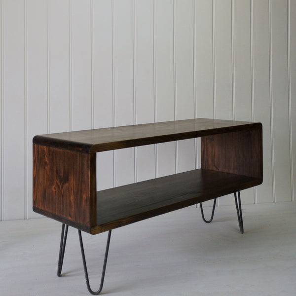 Dark wood mid century style coffee table with magazine shelf standing on hair pin legs